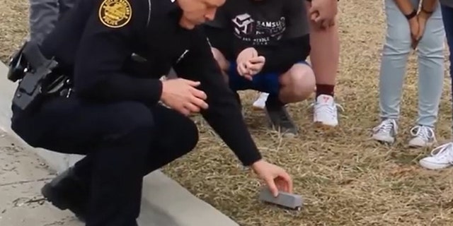 A police officer with the prototype device designed for safely picking up hypodermic needles (Screenshot from Samsung YouTube video)