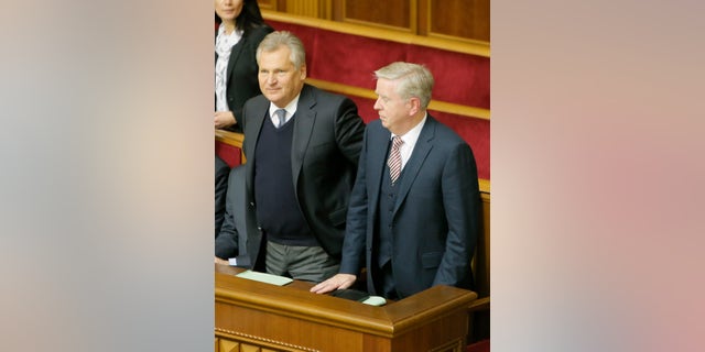 Former President of the European Parliament Patrick Cox, right, and former Polish President Aleksander Kwasniewski, watch a parliament session in Kiev, Ukraine, Wednesday, Nov. 13, 2013. A vote on various bills that would allow the release of Ukraine's jailed former premier Yulia Tymoshenko is scheduled for Wednesday. (AP Photo/Efrem Lukatsky)