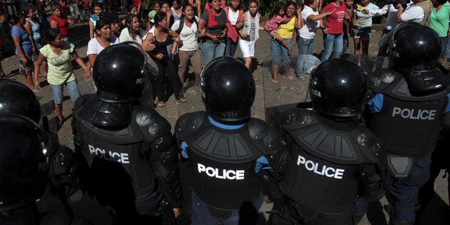 Nov. 7: Supporters of the Liberal Independent Party (PLI) shout slogans against Nicaragua's President Daniel Ortega as they protest election results by the Supreme Electoral Council (CSE) outside their voting center where police are lined up one day after general elections in San Juan de la Concepcion, near Managua, Nicaragua. (AP Photo/Esteban Felix)
