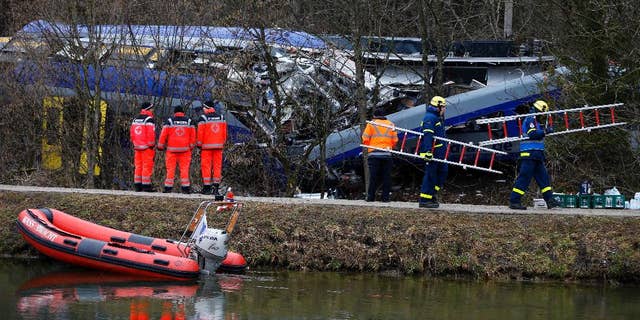 FILE - In this Feb. 10, 2016 file picture rescue personnel stand in front of trains that collided head-on near Bad Aibling, Germany.  Prosecutors are seeking a four-year jail sentence for a train dispatcher accused of negligence that led to one of the worst train crashes in Germany history earlier this year. Twelve people died and 89 people were injured when two commuter trains collided on a single track Feb. 9 near the Bavarian town of Bad Aibling,southeast of Munic. ( Photo/Matthias Schrader,file)
