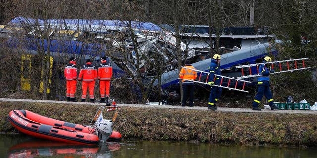 FILE - In this Feb. 10, 2016 file picture rescue personnel stand in front of trains that collided head-on near Bad Aibling, Germany. Prosecutors are seeking a four-year jail sentence for a train dispatcher accused of negligence that led to one of the worst train crashes in Germany history earlier this year. Twelve people died and 89 people were injured when two commuter trains collided on a single track Feb. 9 near the Bavarian town of Bad Aibling,southeast of Munic. ( Photo/Matthias Schrader,file)