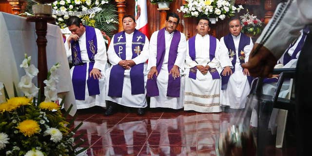 Priests attend the funeral Mass for slain Rev. Jose Alfredo Suarez de la Cruz at Our Lady of Asuncion Church in Paso Blanco, Veracruz state, Mexico, Wednesday, Sept. 21, 2016. Mourners packed the church for the funeral Mass in memory of the Roman Catholic priest who was murdered along with another cleric in the troubled Gulf coast state of Veracruz. (AP Photo/Marco Ugarte)
