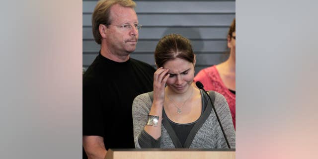 Oct. 4, 2011: Amanda Knox tries to gain her composure to make a statement to the media as her father, Curt Knox, stands behind, shortly after her arrival at Seattle-Tacoma International Airport in Seattle. Knox was freed on October 3 after an Italian appeals court acquitted her on murder charges after four years in prison. Curt Knox says Amanda would like to go back to her university and finish her degree, but that he worries about what the time in prison has done to his 24-year-old daughter.