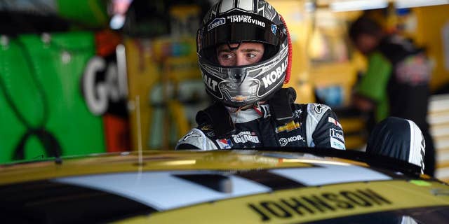 Driver Jimmie Johnson climbs into his car before practice for the NASCAR Sprint Cup series auto race, Friday, Sept. 26, 2014, at Dover International Speedway in Dover, Del. (AP Photo/Nick Wass)