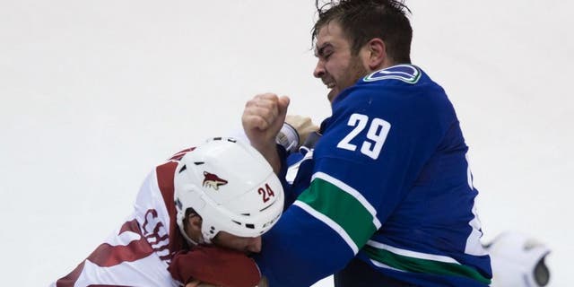 Vancouver Canucks' Tom Sestito, right, and Arizona Coyotes' Kyle Chipchura fight during the second period of an NHL hockey game in Vancouver, British Columbia, Monday, Dec. 22, 2014. (AP Photo/The Canadian Press, Darryl Dyck)
