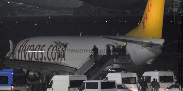 Passengers of private Turkish company Pegasus leave the plane at the Sabiha Gokcen Airport in Istanbul, Turkey, Friday, Feb. 7, 2014. An official says authorities have subdued a man who attempted to hijack a Turkish plane to Sochi, Russia, and that the other passengers have been evacuated. Huseyin Avni Mutlu, the Istanbul governor, says on Twitter that "the operation has ended." In another tweet Friday, he said all passengers were evacuated "without any problems."(AP Photo/Emrah Gurel)