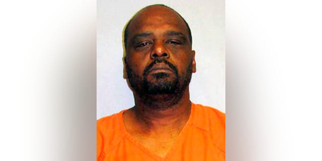 This photo provided by the Hawaii Police Department shows John Ali Hoffman. Officers on Friday, May 6, 2016 found a woman's body stuffed in the trunk of a car that was driving away from a house in a rural area of Hawaii's Big Island before walking into the home and coming across two juveniles dead. ohn Ali Hoffman was arrested on suspicion of three counts of murder and firearms offense. (Hawaii Police Department via AP) MANDATORY CREDIT