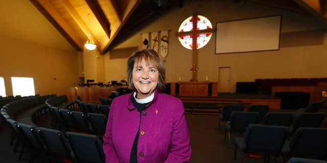 In this Wednesday, April 19, 2017, photo, Bishop Karen Oliveto poses for a photo in the sanctuary of a United Methodist Church in Highlands Ranch, Colo. The top court in the United Methodist Church on Tuesday, April 25, will consider whether the election of Oliveto, the first openly lesbian Methodist bishop, violated church law barring clergy who are ``self-avowed practicing homosexuals.’’ (AP Photo/David Zalubowski)