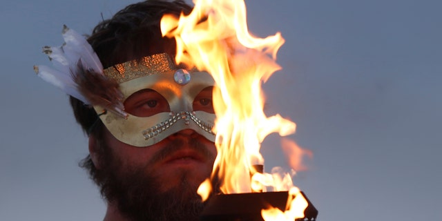 A participant takes part in a fire ceremony as approximately 70,000 people from all over the world gathered for the annual Burning Man arts and music festival in the Black Rock Desert of Nevada in 2017. 