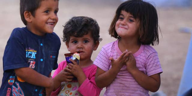 Iraqi refugees children play at Khazir refugee camp outside Irbil, 217 miles (350 kilometers) north of Baghdad, Iraq, Thursday, June 12, 2014. The Islamic State of Iraq and the Levant, the al-Qaida breakaway group, on Monday and Tuesday took over much of Mosul in Iraq and then swept into the city of Tikrit further south. An estimated half a million residents fled Mosul, the economically important city. (AP Photo)