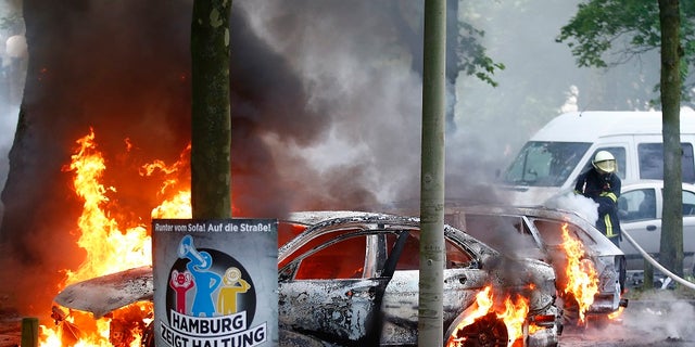 German firefighters put out a number of cars that have been set ablaze near the G-20 summit in Hamburg, Germany, on Friday, July 7, 2017.