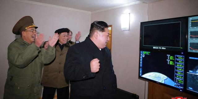 Kim Jong Un and his scientists celebrate the launch of an intercontinental ballistic missile.