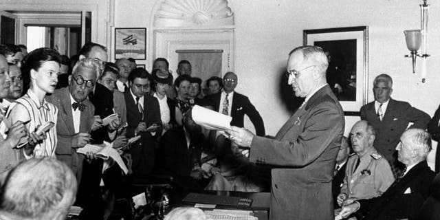 FILE - In this Aug. 14, 1945, file photo, President Harry S. Truman reads to newsmen his announcement of the Japanese surrender officially signaling the war's end during a White House, Washington. At the right of the President are Secretary of State James F. Byrnes and Admiral William D. Leahy, Presidential Chief of Staff. (AP Photo)