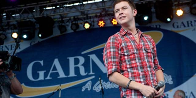 GARNER, NC - MAY 14: American Idol" finalist Scotty McCreery performs at an outdoor concert for adoring local fans at his homecoming celebration at Buffaloe Park May 14, 2011 in Garner, North Carolina. In the past six weeks, McCreery has gone from being a cashier at Lowes Foods and a singer known only around the Triangle to being a national if not global phenomenon on "American Idol." Residence and town officials prepared a hometown hero's welcome for McCreery two days after he advanced to become one of three top finalist in season ten of America Idol. (Photo by Steve Exum/Getty Images)