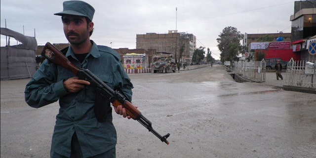 FILE: An Afghan policeman stands guard on the road leading to the Kandahar police headquarters in Kandahar south of Kabul, Afghanistan.