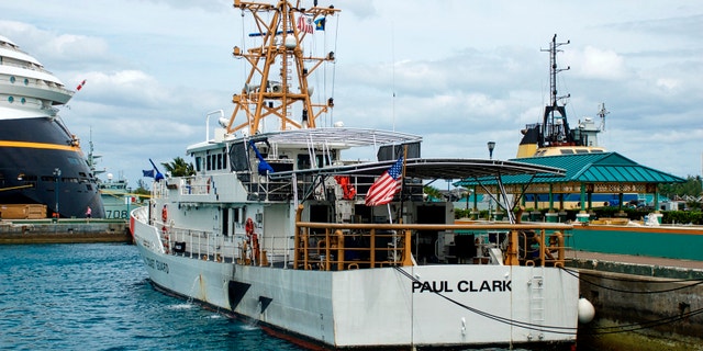 The U.S. Coast Guard ship "Paul Clark" sits dockside at port in Nassau, The Bahamas, as the stern of the Disney Dream passenger cruise ship.