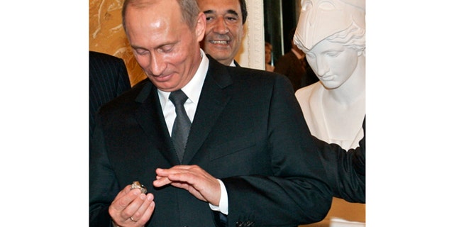 FILE - In this June 25, 2005, file photo, Russian President Vladimir Putin holds a diamond-encrusted 2005 Super Bowl ring belonging to New England Patriots NFL football team owner Robert Kraft during a meeting of American business executives at the 18th century Konstantin Palace outside St. Petersburg, Russia. When Putin arrived in London on Sunday, June 16, 2013, his spokesman was asked about a New York Post story quoting Kraft saying Putin pocketed his Super Bowl ring in 2005. Putin said hes happy to buy New England Patriots owner Robert Kraft another ring, but its absurd to suggest he stole the Super Bowl one. (AP Photo/Alexander Zemlianichenko, File)