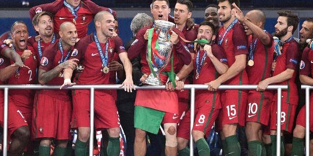 Portugal's Cristiano Ronaldo holds the trophy after winning the Euro 2016 final soccer match between Portugal and France at the Stade de France in Saint-Denis, north of Paris, Sunday, July 10, 2016. (AP Photo/Martin Meissner)