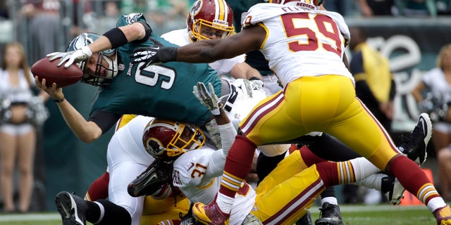 Philadelphia Eagles quarterback Nick Foles (9) dives into the end zone for a touchdown as Washington Redskins inside linebacker London Fletcher (59) reaches to stop him during the first half of an NFL football game in Philadelphia, Sunday, Nov. 17, 2013. (AP Photo/Matt Slocum)