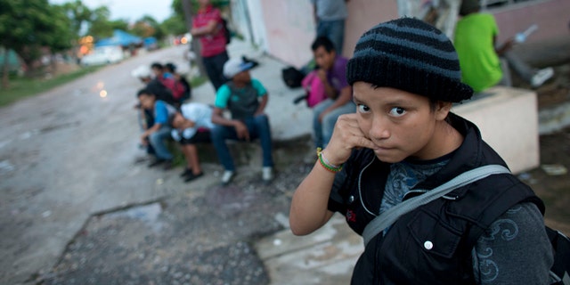 In this June 19, 2014 photo, a 14-year-old Guatemalan girl traveling alone waits for a northbound freight train along with other Central American migrants, in Arriaga, Chiapas state, Mexico. The United States has seen a dramatic increase in the number of Central American migrants crossing into its territory, particularly children traveling without any adult guardian. More than 52,000 unaccompanied children have been apprehended since October. (AP Photo/Rebecca Blackwell)