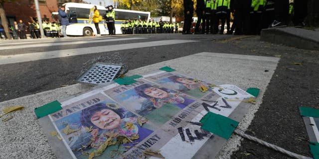 Satirical posters of South Korean President Park Geun-hye are seen on the street near the presidential house in Seoul, South Korea, Wednesday, Nov. 16, 2016. South Korean prosecutors want to question Park this week over suspicion that she let a shadowy longtime confidante manipulate power from behind the scenes, an official said Sunday. (AP Photo/Ahn Young-joon)