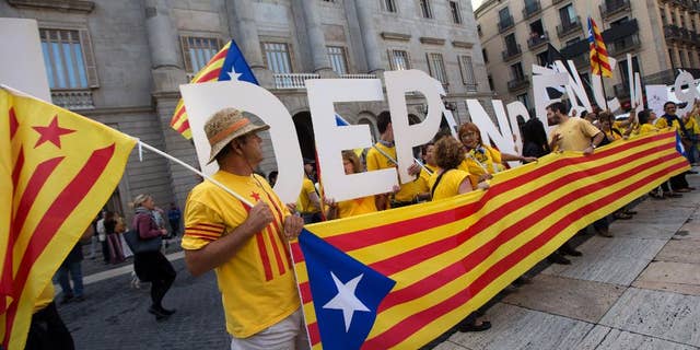 Pro independence supporters gather outside the Generalitat Palace, the main head office of the Government of Catalonia, as Catalonia's regional president Artur Mas, signs the decree to call the referendum in Catalonia in Barcelona, Spain, Saturday, Sept. 27, 2014. The president of Spain's powerful northeastern region of Catalonia on Saturday formally called an independence referendum Nov. 9, the latest secession push in Europe and one of the most serious challenges to the Spanish state of recent years. (AP Photo/Jordi Borras)