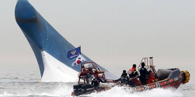 FILE - In this April 16, 2014 file photo, South Korean coast guard officers try to rescue passengers from the Sewol ferry as it sinks in the water off the southern coast near Jindo, south of Seoul, South Korea. It is a decision that has maritime experts stumped and is at odds with standard procedure: Why were the passengers of the doomed South Korean ferry told to stay in their rooms rather than climb on deck? Evacuations can be chaotic and dangerous, and an important principle in maritime circles is that even a damaged ship may be the best lifeboat. But car ferries like the Sewol, which left some 300 people missing or dead when it sank Wednesday, are different. They are particularly susceptible to rapid capsizing which makes it critically important that the crew quickly evacuate passengers when there is trouble. (AP Photo/Yonhap, File) KOREA OUT