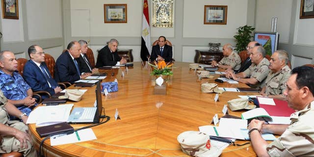 In this photo provided by Egypt's state news agency MENA, Egypt's President Abdel-Fattah el-Sissi, center, holds an emergency meeting of the National Defense Council with top officials after an attack in the Sinai Peninsula, in Cairo, Egypt, Friday, Oct. 24, 2014. The coordinated assault on an army checkpoint in the Sinai Peninsula killed 30 Egyptian troops on Friday, making it the deadliest single attack in decades on the military, which has been struggling to stem a wave of violence by Islamic extremists since the overthrow of Islamist President Mohammed Morsi. El-Sissi, the former defense minister and army chief who overthrew Morsi last year, declared a three-day mourning period. (AP Photo/MENA)