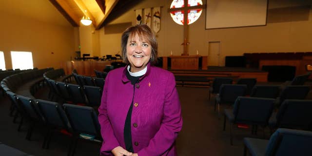 In this Wednesday, April 19, 2017, photo, Bishop Karen Oliveto poses for a photo in the sanctuary of a United Methodist Church in Highlands Ranch, Colo. The top court in the United Methodist Church on Tuesday, April 25, will consider whether the election of Oliveto, the first openly lesbian Methodist bishop, violated church law barring clergy who are ``self-avowed practicing homosexuals.’’ (AP Photo/David Zalubowski)