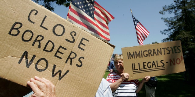 SANTA CLARA, CA - MAY 05: Anti-immigration demonstrators hold signs and American flags during an anti-immigration rally May 5, 2006 in Santa Clara, California. Dozens of anti-immigration demonstrators held a rally as similar rallies were held across the country on Cinco de Mayo to protest illegal immigrants. (Photo by Justin Sullivan/Getty Images)
