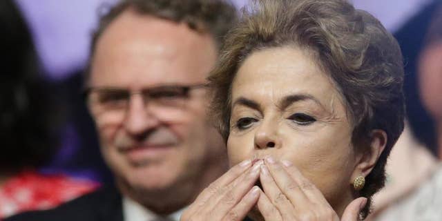 Brazil's President Dilma Rousseff blows kisses during the opening of the National Conference of Women, in Brasilia, Brazil, Tuesday, May 10, 2016. The impeachment proceedings against Rousseff took another hairpin turn Tuesday after the acting speaker of Congress' lower house Waldir Maranhao put the impeachment process back on track a day after he sparked chaos and sowed further discord among Brazil's fractious political class by annulling an April 17 vote by the Chamber of Deputies for impeachment. (AP Photo/Eraldo Peres)