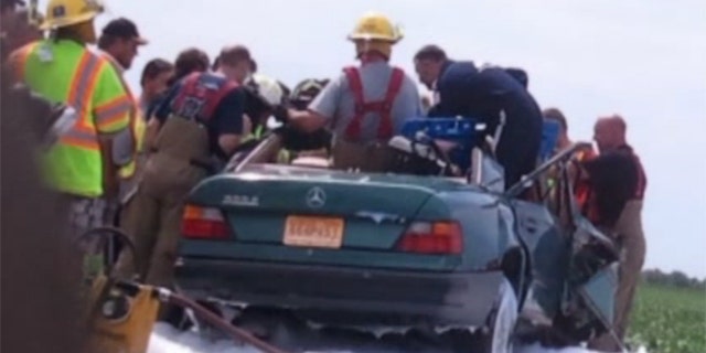 Aug 4, 2013: Firefighters work to rescue a woman from the scene of a car crash in Missouri.