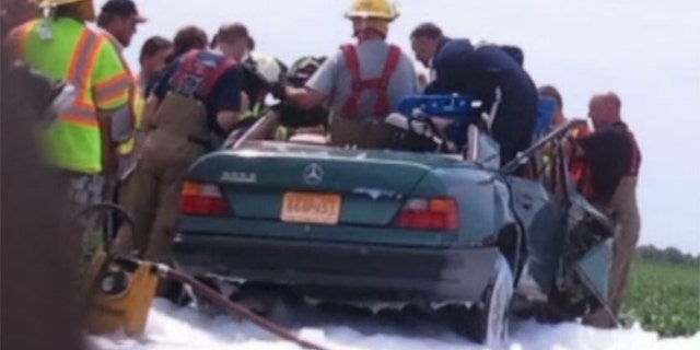 Aug 4, 2013: Firefighters work to rescue a woman from the scene of a car crash in Missouri.
