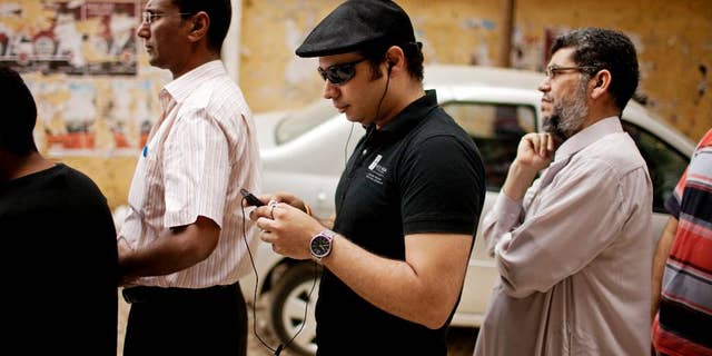 FILE -- In this May 23, 2012 file photo, Ahmed Maher, a co-founder of the April 6 Revolutionary Movement, waits in line to vote in presidential elections after 16 months of interim rule by the Supreme Council of Armed Forces, at a polling center in Cairo, Egypt. Maher, a leading Egyptian activist behind the 2011 uprising that toppled Hosni Mubarak has been released from prison after serving a three-year sentence for violating a ban on unauthorized protests. A lawyer for Maher, Tarek al-Awadi, said Maher will be under surveillance for the next three years as part of his sentence. (AP Photo/Pete Muller, File)
