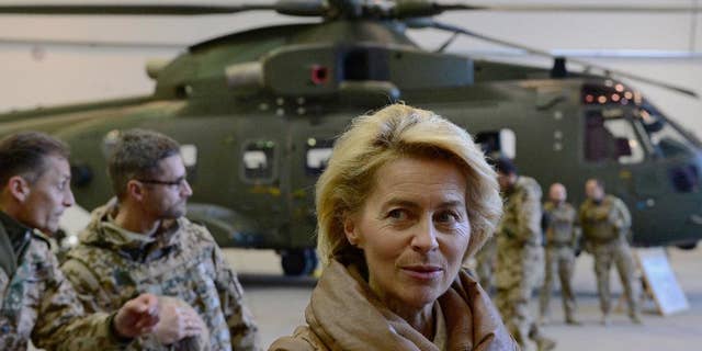 FILE - In this Dec. 13, 2014 file picture German Defense Minister Ursula von der Leyen, center, greets German helicopter pilots in a hangar at Camp Marmal in Mazar-i-Sharif, Afghanistan. Germany is affirming its growing role on the world stage in new security guidelines that mark another step away from its caution after World War II. A draft defense policy paper obtained by The Associated Press Tuesday July 12, 2016 and due to be presented on Wednesday states that "Germany is a globally highly connected country ... which has a responsibility to actively shape the global order." (John MacDougall, Pool Photo via AP, file)