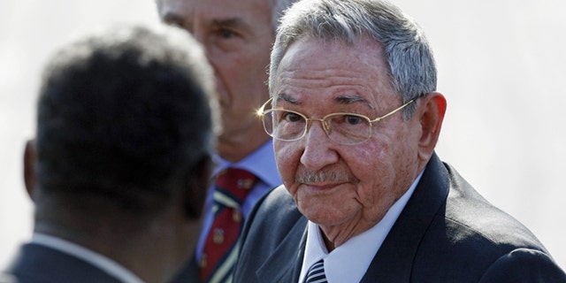Flanked by a bodyguard, left, and a diplomatic protocol officer, Cuba's President Raul Castro makes his way to a waiting car after arriving at the Arturo Merino Benitez International Airport in Santiago, Chile, Friday, Jan. 25, 2013. Castro along with other Latin American, Caribbean and European leaders are gathering in Santiago for this weekend's CELAC-EU economic summit. (AP Photo/Luis Hidalgo)
