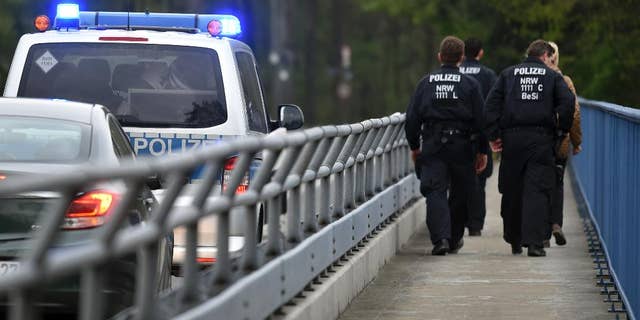 Policemen are on their way to search for evidence in Dortmund, Germany, Friday, April 14, 2017. After the attack on the team bus of Borussia Dortmund soccer club Tuesday, April 11, 2017, the used explosives and the ignition mechanism are in focus of the investigations (Caroline Seidel/dpa via AP)