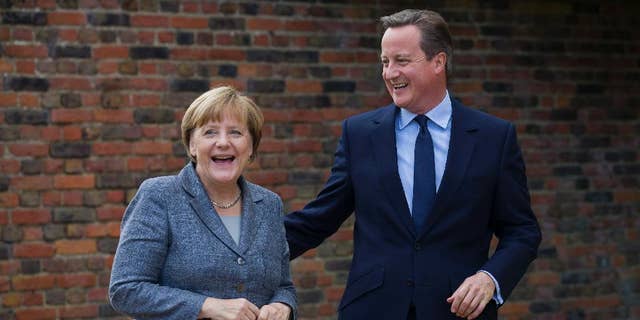British Prime Minister David Cameron smiles as he talks with German Chancellor Angela Merkel during their meeting at Chequers, the prime minister's official country residence, near Ellesborough, northwest of London, Friday Oct. 9, 2015. (Justin Tallis/Pool via AP)