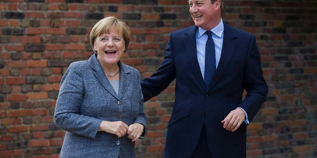 British Prime Minister David Cameron smiles as he talks with German Chancellor Angela Merkel during their meeting at Chequers, the prime minister's official country residence, near Ellesborough, northwest of London, Friday Oct. 9, 2015. (Justin Tallis/Pool via AP)