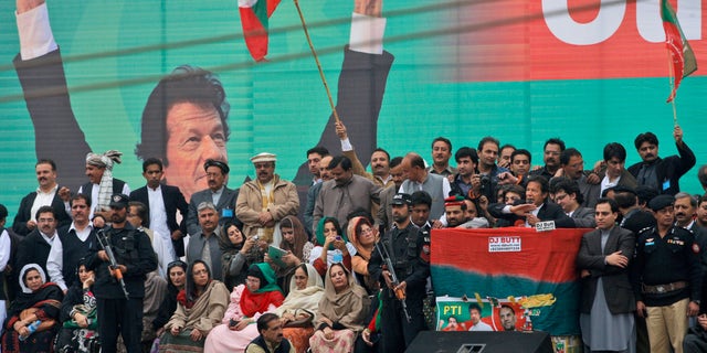Nov. 23, 2013: Pakistan's cricketer-turned politician Imran Khan, leader of Pakistan Tehreek-e-Insaf party, with a microphone at center right, surrounded by security men and party members, delivers a speech to his supporters during a protest against U.S. drone strikes in Pakistan, in Peshawar, Pakistan. Thousands of people protesting U.S. drone strikes blocked a road in northwest Pakistan on Saturday used to truck NATO troop supplies and equipment in and out of Afghanistan, the latest sign of rising tension caused by the attacks.