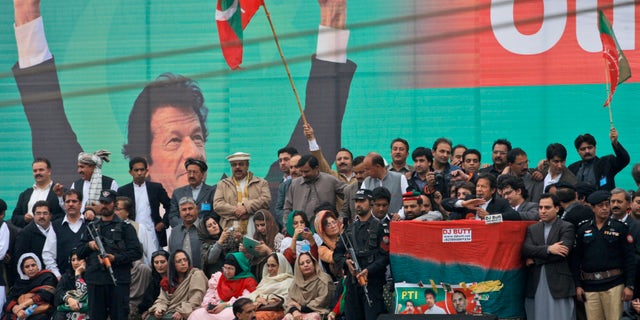 Nov. 23, 2013: Pakistan's cricketer-turned politician Imran Khan, leader of Pakistan Tehreek-e-Insaf party, with a microphone at center right, surrounded by security men and party members, delivers a speech to his supporters during a protest against U.S. drone strikes in Pakistan, in Peshawar, Pakistan. Thousands of people protesting U.S. drone strikes blocked a road in northwest Pakistan on Saturday used to truck NATO troop supplies and equipment in and out of Afghanistan, the latest sign of rising tension caused by the attacks.