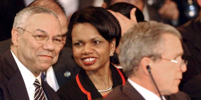 FILE - In this Jan. 13, 2004 file photo, Secretary of State Colin Powell talks with National Security Adviser Condoleezza Rice during the plenary session of the Special Summit of the Americas in Monterrey, Mexico. President Bush sits in the foreground. (AP Photo/Jaime Puebla, File)