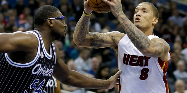Miami Heat's Michael Beasley (8) goes up for a shot as he is defended by Orlando Magic's Jason Maxiell (54) during the first half of an NBA basketball game, Saturday, Jan. 4, 2014, in Orlando, Fla. (AP Photo/John Raoux)