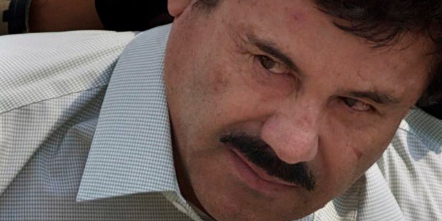 FILE - In this Feb. 22, 2014 file photo, Joaquin 'El Chapo' Guzman is escorted to a helicopter in handcuffs by Mexican Navy marines at a navy hanger in Mexico City. (AP Photo/Eduardo Verdugo, File)