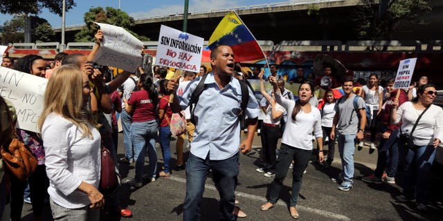 Un empleado del diario El Nacional sostiene un cartel que dice "sin información no hay democracia" durante una protesta afuera del Centro Nacional de Comercio Exterior, organismo oficial encargado de otorgar los permisos para vender dólares en Caracas, Venezuela, el 28 de Enero de 2014. Mientras que decenas de periódicos han sido víctimas de una política cambiaria que dificulta la importación de insumos, El Nacional está luchando para poder importar papel en medio de una creciente escasez del insumo que obligaría a muchas publicaciones a cerrar sus operaciones en las próximas semanas pues las reservas de papel han caído a su punto más bajo. (AP Foto/Fernando Llano)
An employee of El Nacional newspaper holds up a sign that reads in Spanish "Without information, there is no democracy", during a protest outside the Cadivi agency, which controls foreign currency in Caracas, Venezuela, Tuesday, Jan. 28, 2014. While newspapers have been beset for years by currency controls that make it difficult to import supplies, El Nacional is scrambling for newsprint as worsening shortages threaten to take several publications out of circulation in the coming weeks as reserves of newsprint have fallen to an all-time low. (AP Photo/Fernando Llano)