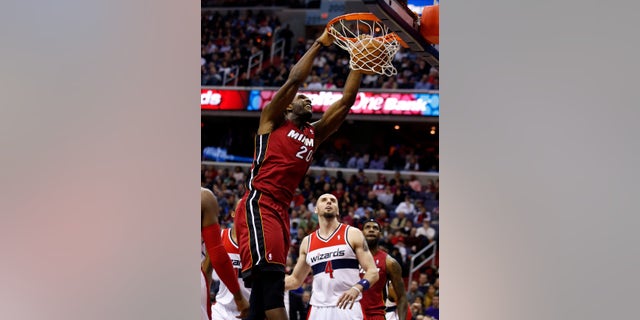 Miami Heat center Greg Oden (20) dunks the ball in front of Washington Wizards center Marcin Gortat (4), from Poland, in the first half of an NBA basketball game on Wednesday, Jan. 15, 2014, in Washington. It was Oden's first NBA regular-season game in more than four years. (AP Photo/Alex Brandon)