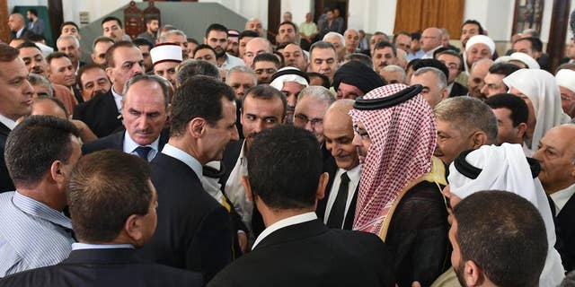 In this photo released on the official Facebook page of the Syrian Presidency, Syrian President Bashar Assad, greets people at the Safa Mosque on the first day of Eid al-Fitr, that marks the end of the Muslim holy month of Ramadan, in Homs, Syria, Wednesday, July 6, 2016. (Syrian Presidency via AP)