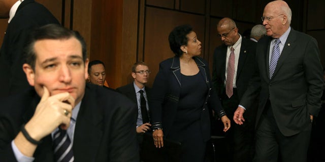 WASHINGTON, DC - JANUARY 28: Sen. Patrick Leahy (D-VT) (R) escorts Loretta Lynch back from a lunch break as Sen. Ted Cruz (R-TX) (L) sits nearby during her confirmation hearing before the Senate Judiciary Committee January 28, 2015 on Capitol Hill in Washington, DC. If confirmed by the full Senate Ms. Lynch will succeed Eric Holder as the next U.S. Attorney General. (Photo by Mark Wilson/Getty Images)