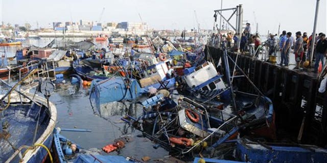 Fishing boats washed ashore by a small tsunami, sit in Caleta Riquelme, adjacent to the port, in the northern town of Iquique, Chile, after magnitude 8.2 earthqauke struck the northen coast of Chile, Wednesday, April 2, 2014. Authorities lifted tsunami warnings for Chiles long coastline early Wednesday. Six people were crushed to death or suffered fatal heart attacks, a remarkably low toll for such a powerful shift in the Earths crust. (AP Photo/Cristian Viveros) NO PUBLICAR EN CHILE