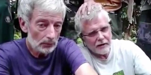 This image made from undated militant video, shows Canadians John Ridsdel, right, and Robert Hall. Canada's Prime Minister Justin Trudeau confirmed that the decapitated head of a Caucasian male recovered Monday, April 25, 2016, in the southern Philippines belongs to Ridsdel, who was taken hostage by Abu Sayyaf militants in September 2015.